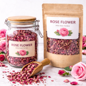Dried rose flower petals displayed in a clear glass jar and kraft pouch with wooden scoop on a light apothecary-style background
