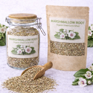 Organic dried marshmallow root cut and sifted in a glass jar and kraft resealable pouch with wooden scoop spilling loose root pieces on marble surface, fresh marshmallow flowers and green leaves arranged around packaging.