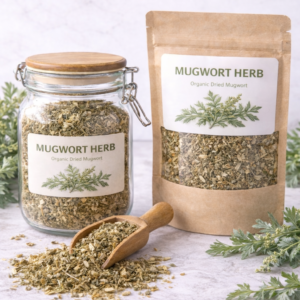 Glass jar and kraft paper pouch filled with organic dried mugwort herb on a marble surface, wooden scoop spilling loose mugwort leaves with fresh sprigs arranged around the packaging.