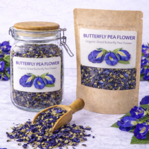 Deep indigo-blue dried butterfly pea flowers with delicate folded petals, displayed in a glass jar against a neutral herbal apothecary background.