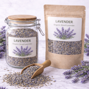 Clear glass jar and kraft paper pouch filled with organic dried lavender buds, surrounded by fresh lavender sprigs and a wooden scoop spilling lavender on a marble surface.